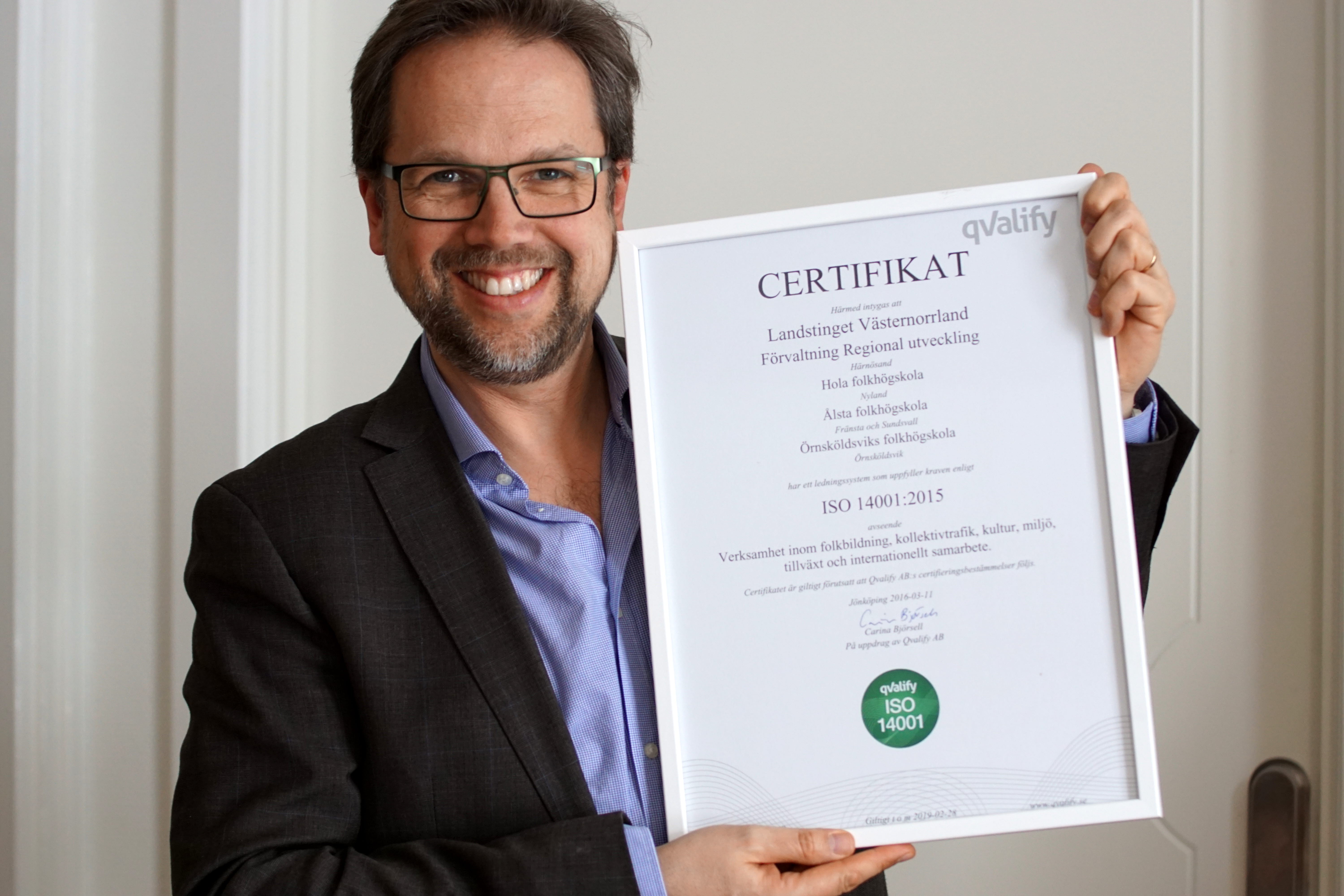 HansOlov Furberg håller upp en tavla med certifikatet för ISO 14001