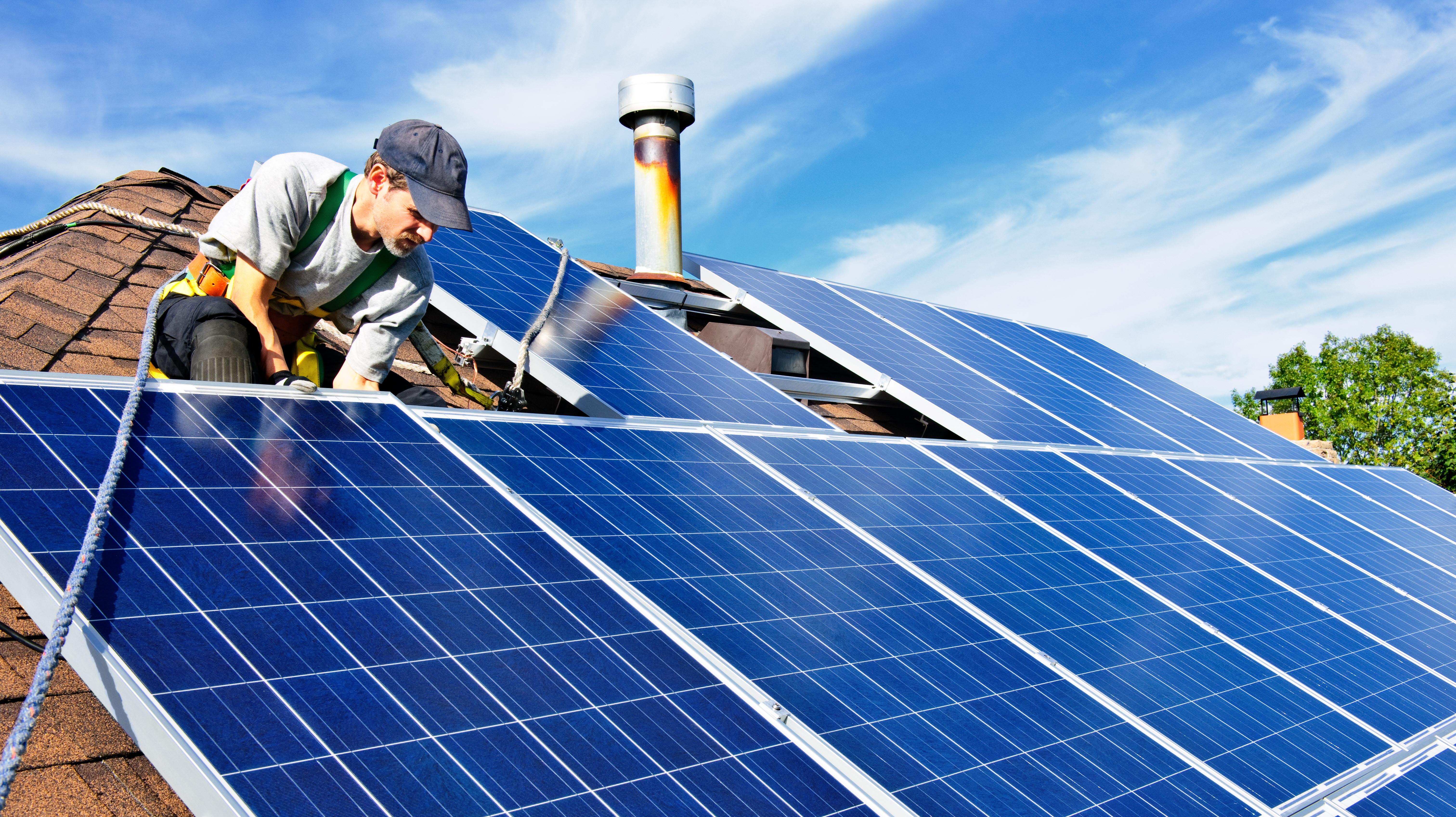 En man som installerar solceller på ett tak