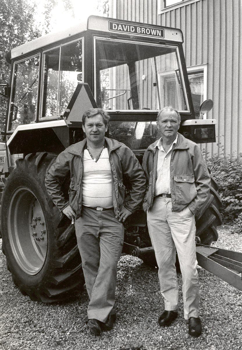 Två personer framför en traktor.